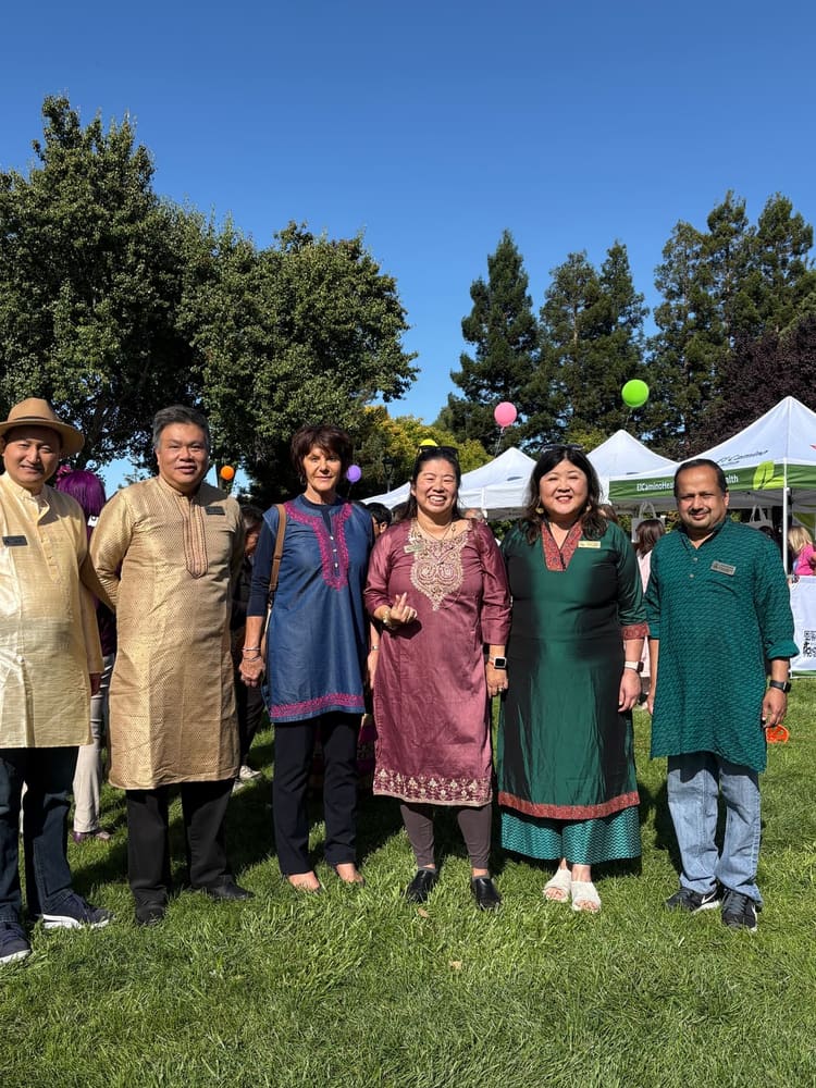 Satheesh Madhathil with community members at an outdoor cultural festival